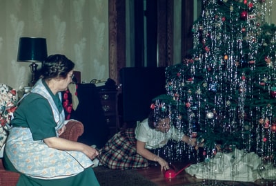 A woman sitting under the Christmas tree
